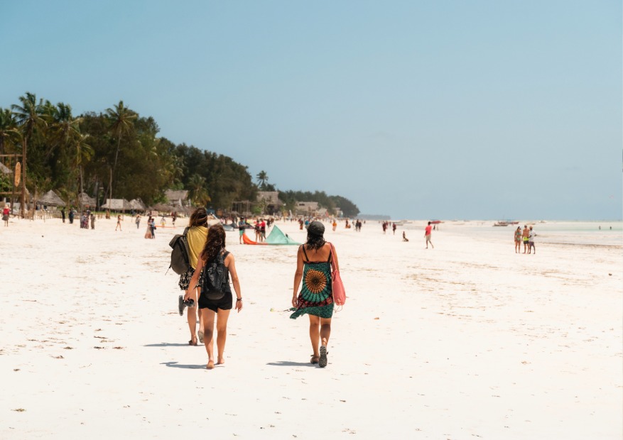 Tourists enjoying an easy walk at the beach of nungwi